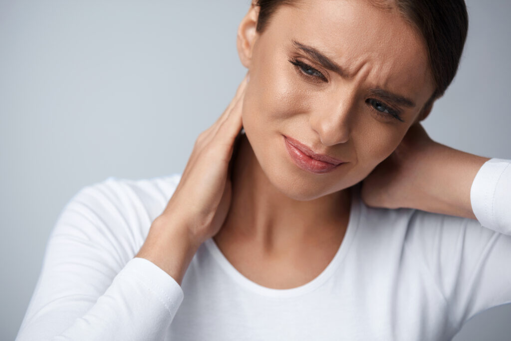 A woman with chronic pain holding her neck