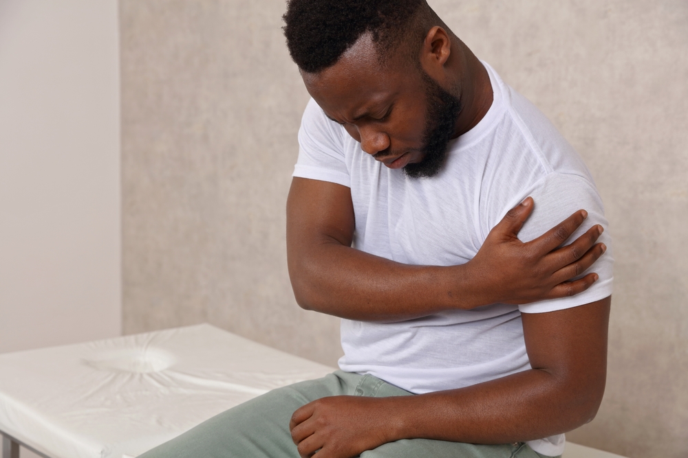A man holding his shoulder before PRP therapy for soft tissue injuries